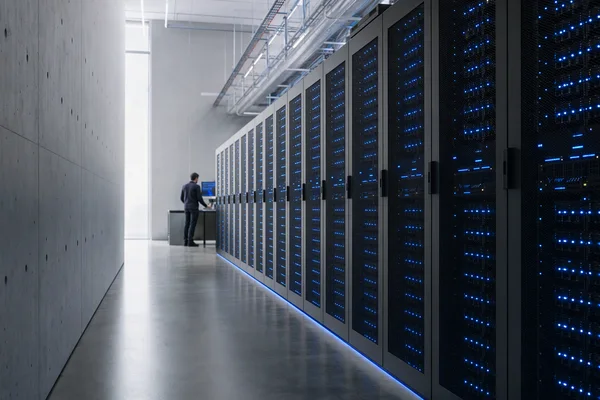 A long data-centre aisle between rows of graphite server racks with small status lights